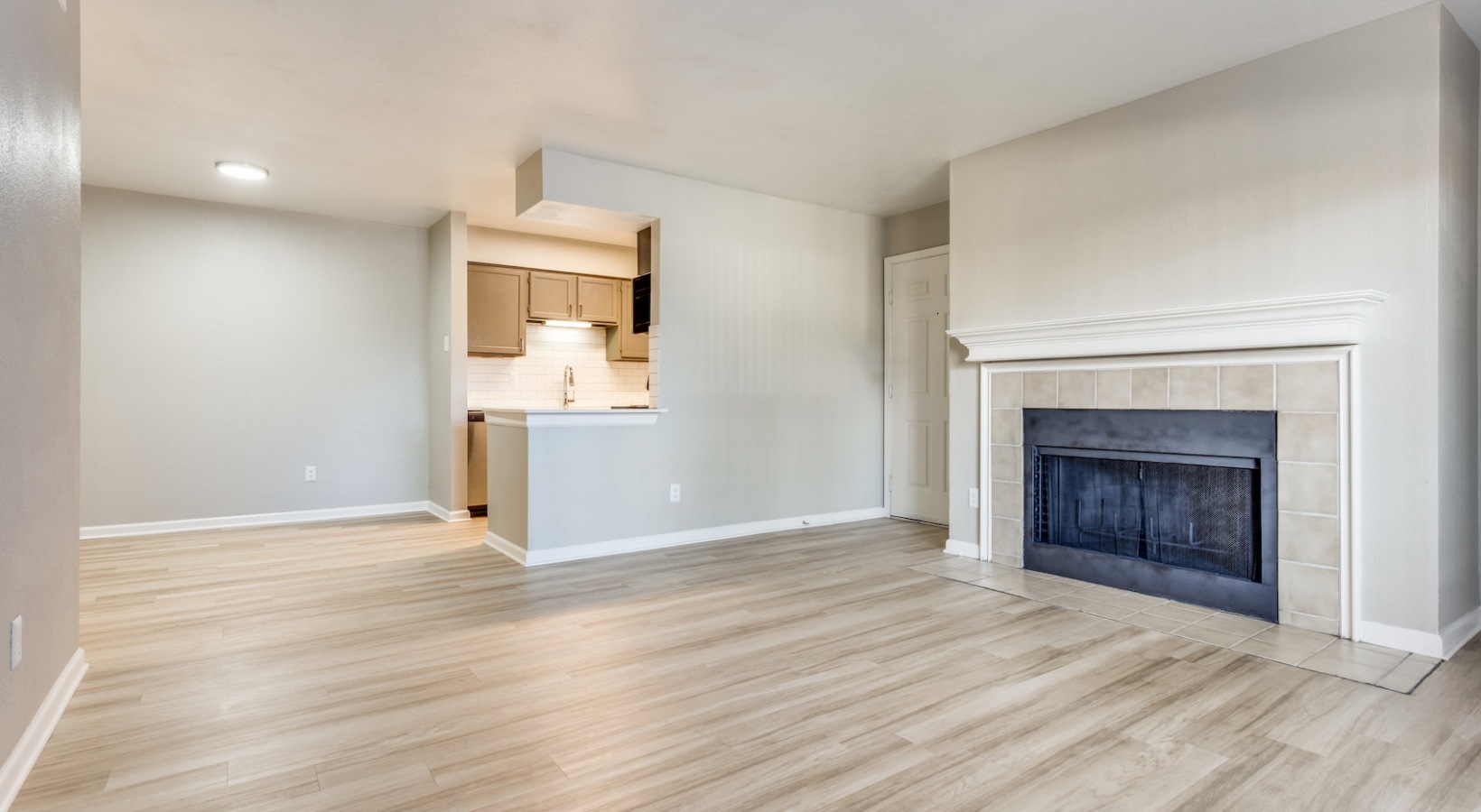 empty living room with fireplace and wood floors at The Richmond