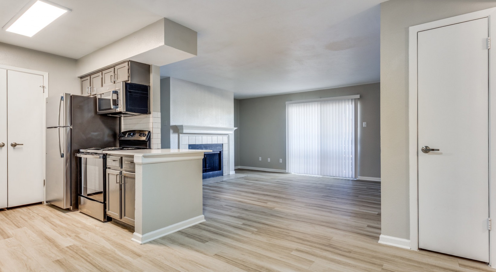 a kitchen with stainless steel appliances and hardwood floors at The Richmond