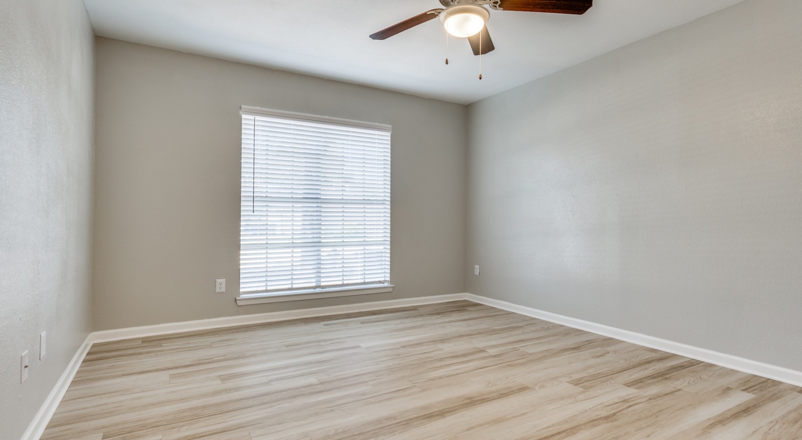 empty room with hardwood floors and ceiling fan at The Richmond