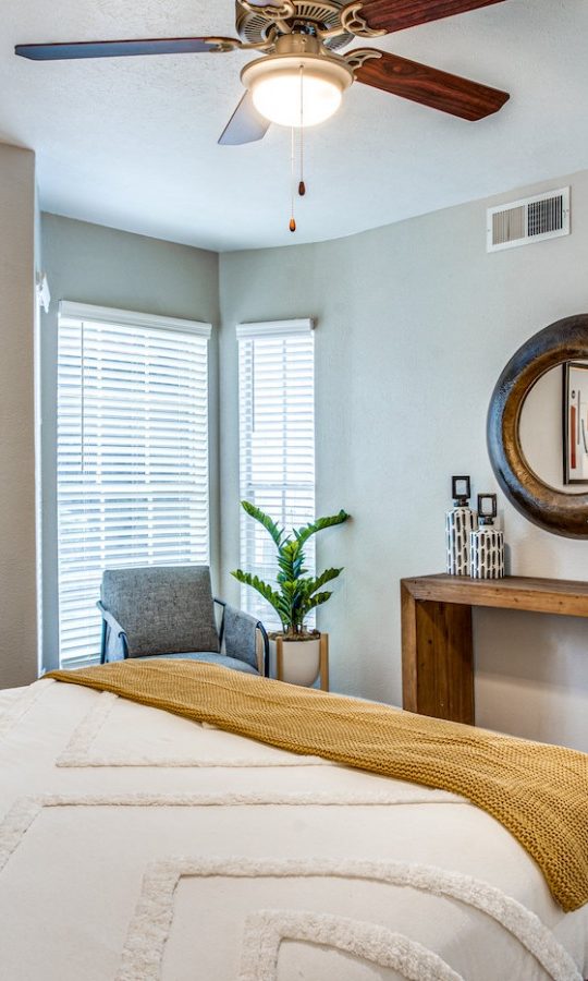 a bedroom with a bed, dresser and ceiling fan at The Richmond