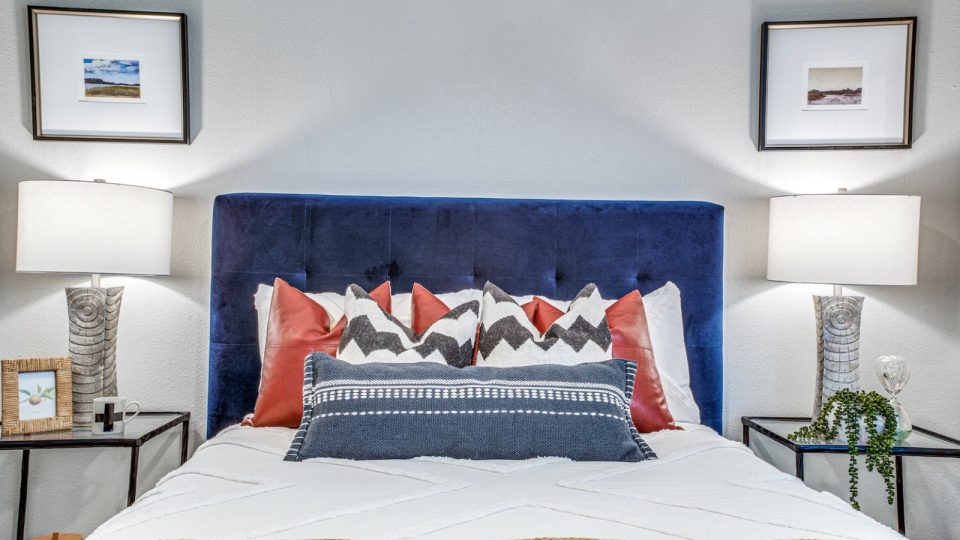 a bed with a blue headboard and a white bedspread at The Richmond
