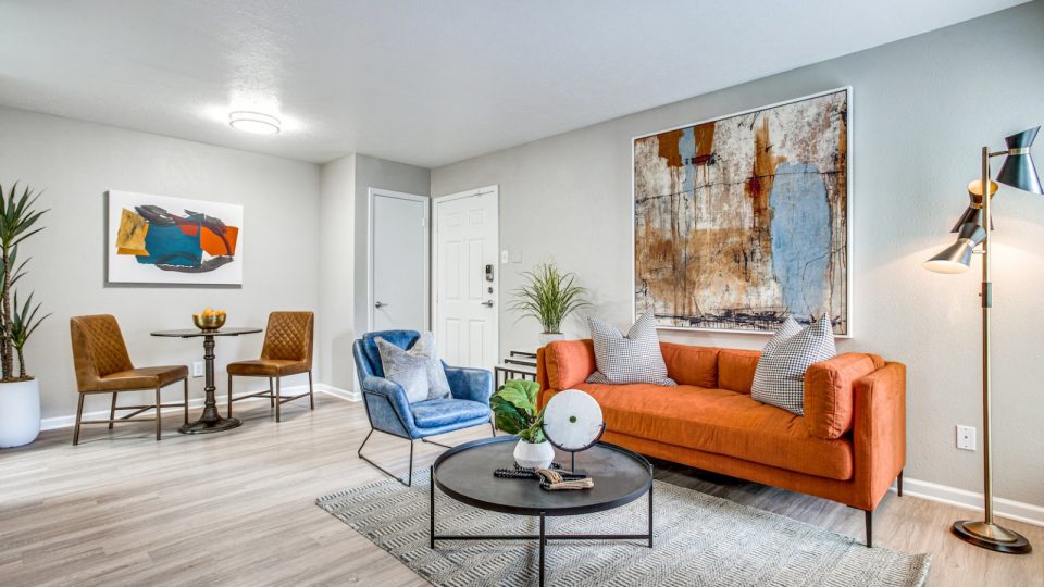 a living room with orange furniture and a painting on the wall at The Richmond