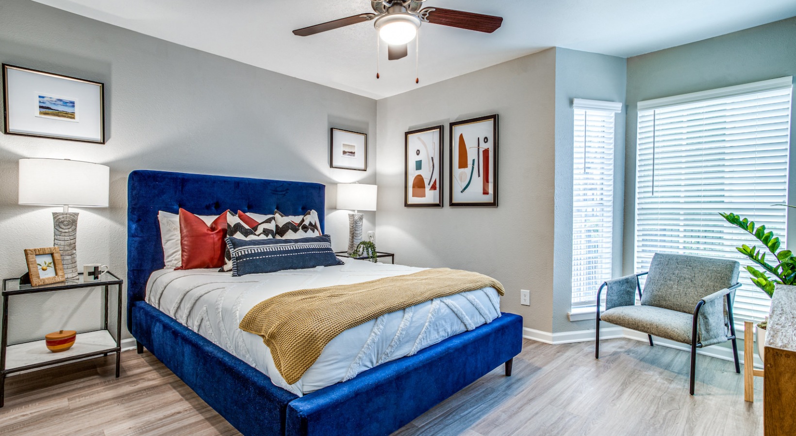 a bedroom with blue and orange bedding and a ceiling fan at The Richmond